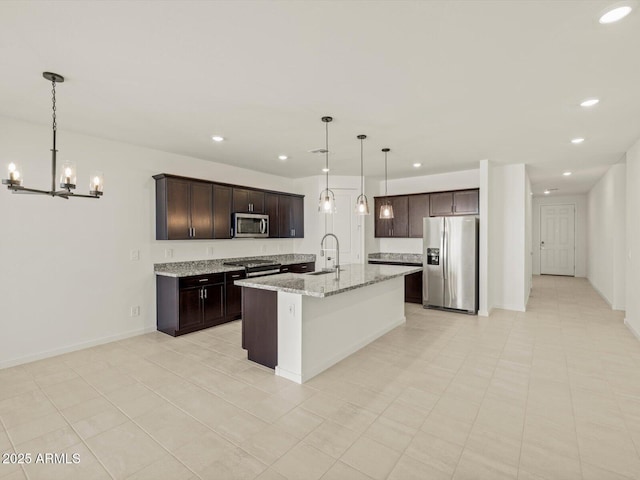 kitchen featuring appliances with stainless steel finishes, sink, pendant lighting, and dark brown cabinetry