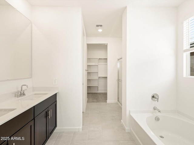 bathroom with vanity, tile patterned floors, and a washtub