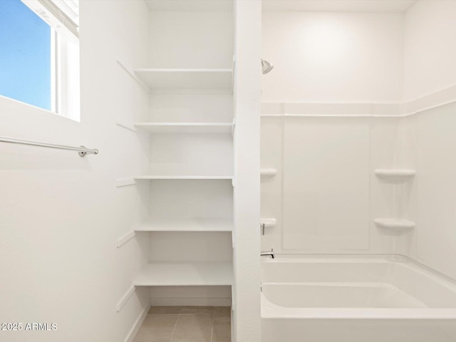 bathroom with tile patterned flooring and  shower combination