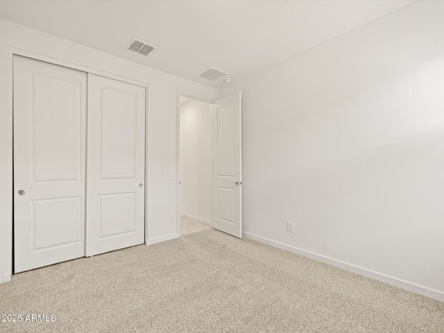 unfurnished bedroom with light carpet and a closet