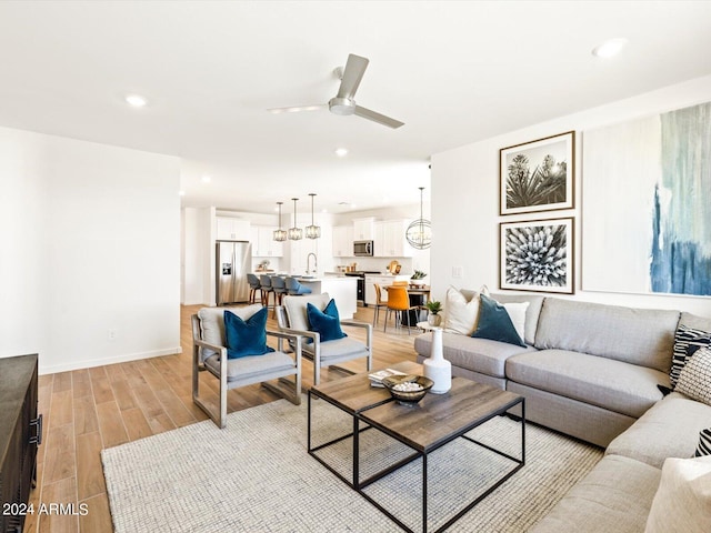 living room with ceiling fan and sink