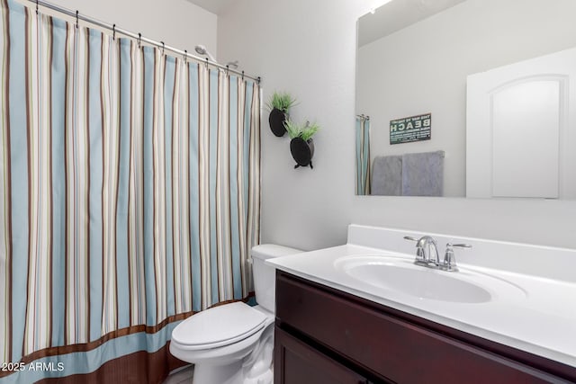 bathroom featuring toilet, vanity, and a shower with curtain