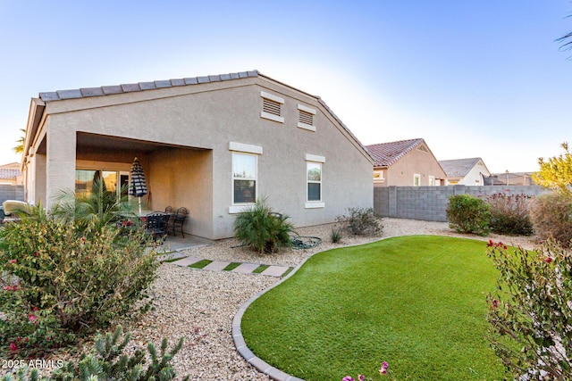 back of house with a yard and a patio area