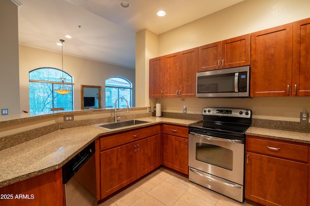 kitchen featuring brown cabinetry, light tile patterned floors, stainless steel appliances, and a sink