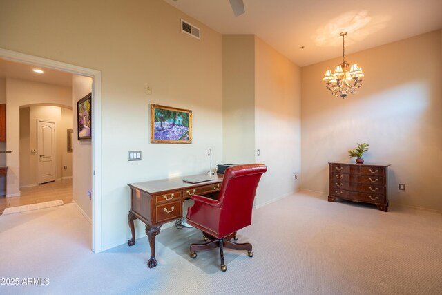 office with carpet, visible vents, arched walkways, and a chandelier