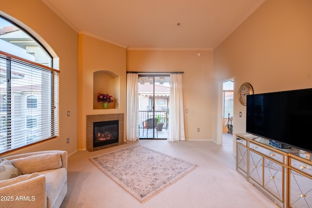 carpeted living area with baseboards, crown molding, and a tile fireplace