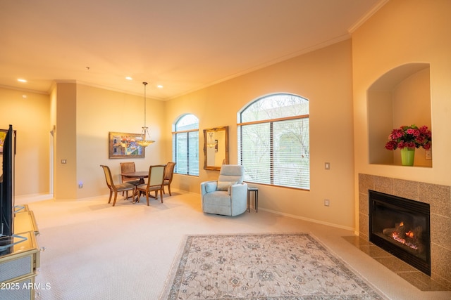 sitting room with carpet, crown molding, baseboards, and a tile fireplace