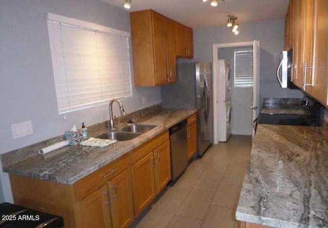 kitchen with stainless steel appliances, brown cabinets, and a sink