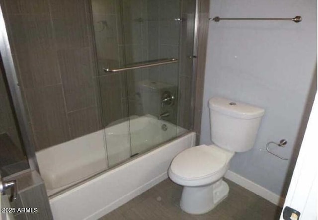 full bathroom with toilet, enclosed tub / shower combo, and baseboards