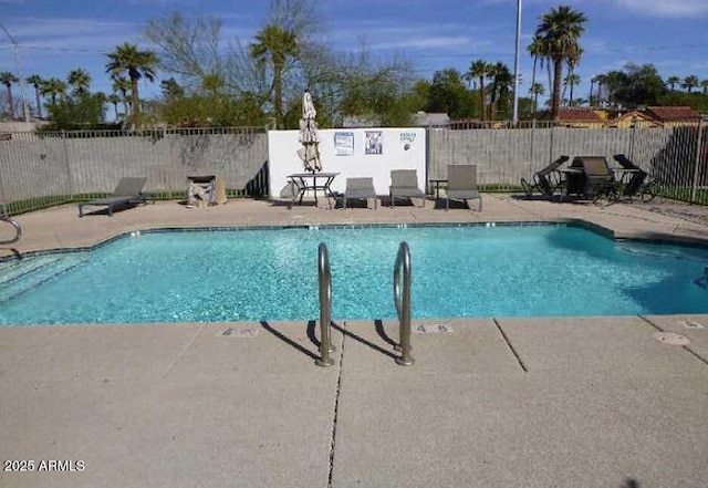 community pool featuring fence and a patio