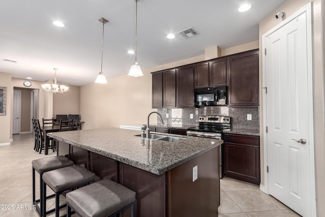 kitchen featuring electric range, visible vents, black microwave, and a sink