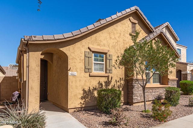 view of front of house featuring a tiled roof and stucco siding