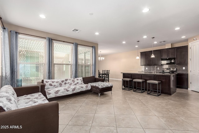 living room with recessed lighting, visible vents, and light tile patterned floors