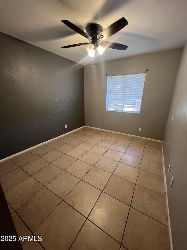 tiled spare room featuring ceiling fan