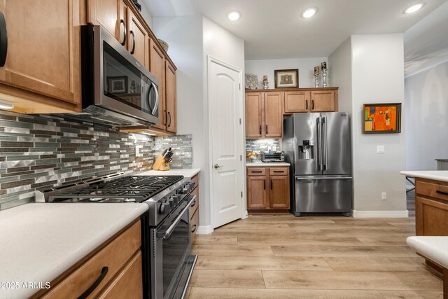6135 E Livingston Loop, Prescott Valley, AZ 86314 - kitchen featuring stainless steel appliances, light wood-style floors, brown cabinets, light countertops, and recessed lighting