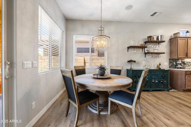 6135 E Livingston Loop, Prescott Valley, AZ 86314 - dining space with light wood-style floors, a chandelier, and baseboards