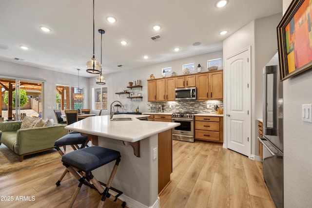 6135 E Livingston Loop, Prescott Valley, AZ 86314 - kitchen with stainless steel appliances, light countertops, a sink, a kitchen breakfast bar, and recessed lighting
