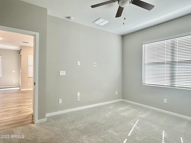 carpeted empty room with ceiling fan and a wealth of natural light