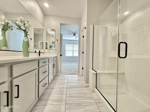 bathroom featuring an enclosed shower, ceiling fan, and vanity