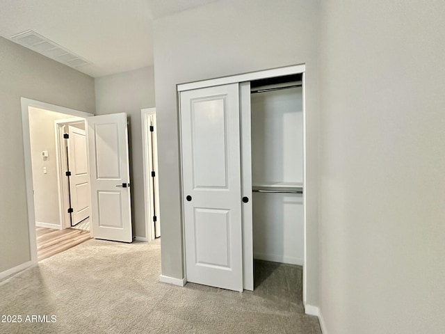 unfurnished bedroom featuring a closet and light carpet