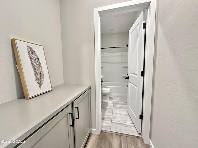 full bathroom with bathtub / shower combination, wood-type flooring, toilet, and vanity