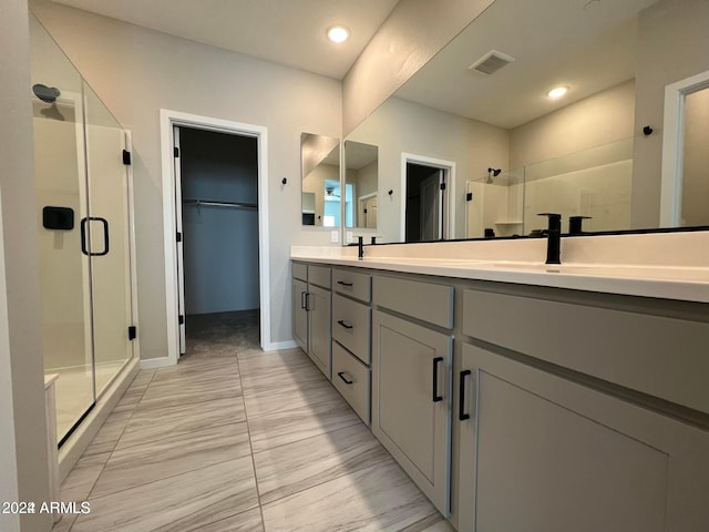 bathroom with a shower with shower door and vanity