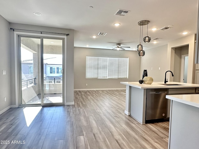 kitchen with light hardwood / wood-style floors, stainless steel dishwasher, sink, decorative light fixtures, and ceiling fan