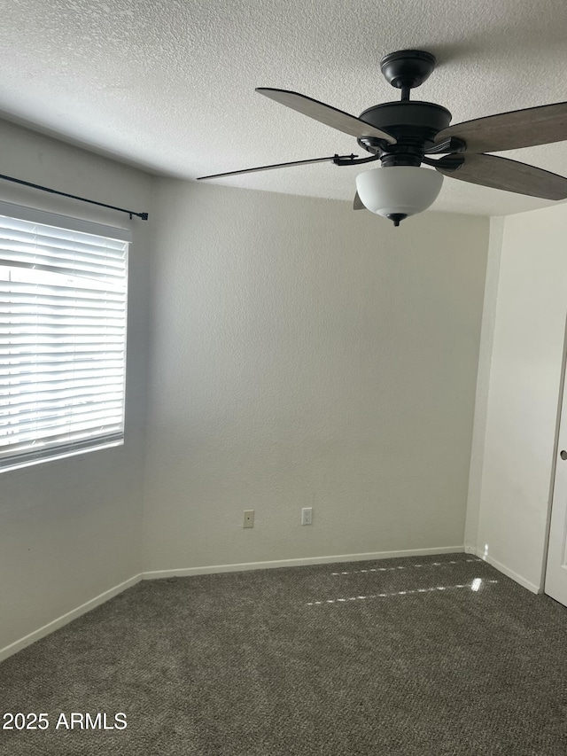 spare room with dark carpet, a textured ceiling, and ceiling fan