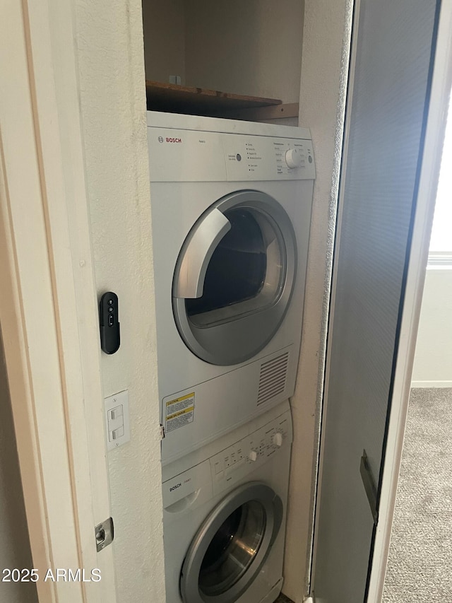 laundry area featuring carpet floors and stacked washer and clothes dryer