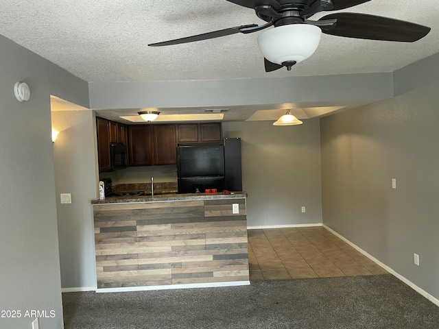 kitchen with sink, dark brown cabinets, dark carpet, ceiling fan, and black appliances