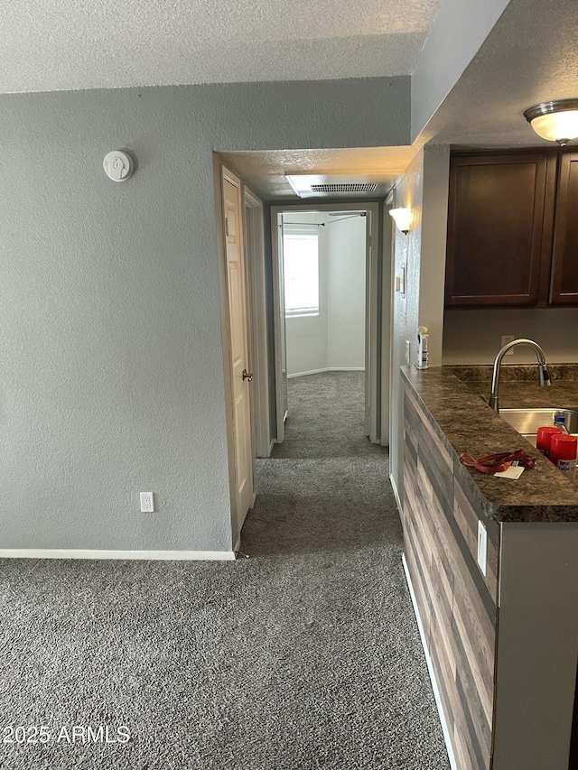 corridor with sink and a textured ceiling