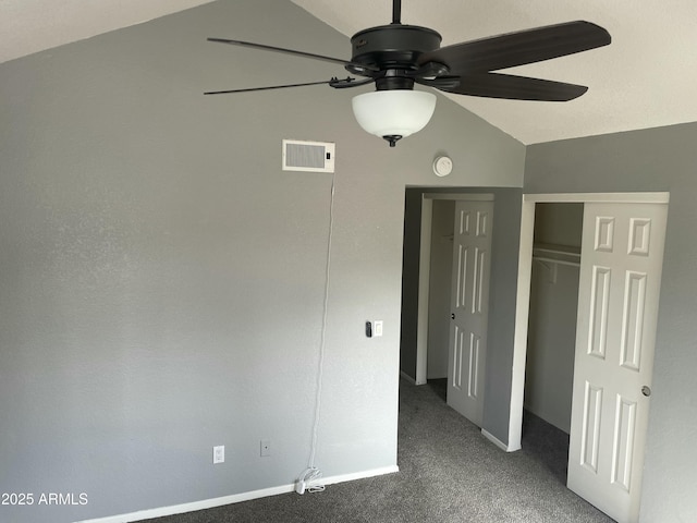 unfurnished bedroom featuring carpet floors, vaulted ceiling, a closet, and ceiling fan