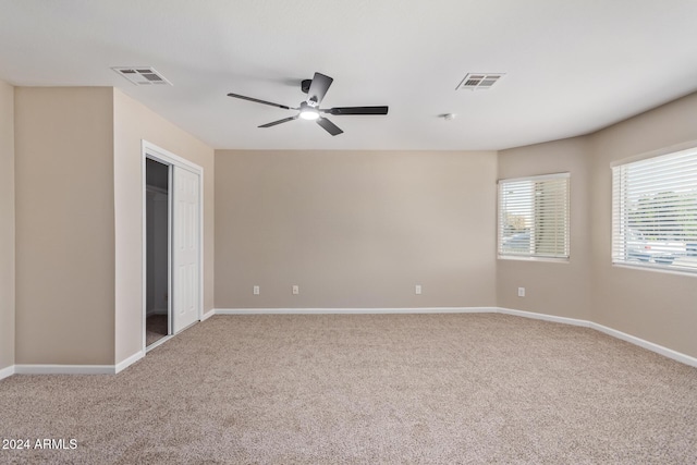 spare room featuring ceiling fan and light colored carpet