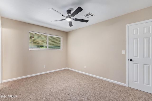 carpeted spare room featuring ceiling fan