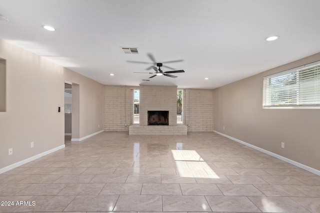 unfurnished living room featuring ceiling fan, a fireplace, and light tile patterned flooring