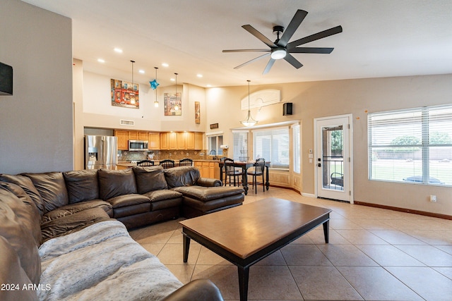 living room featuring light tile patterned floors, high vaulted ceiling, ceiling fan, and sink