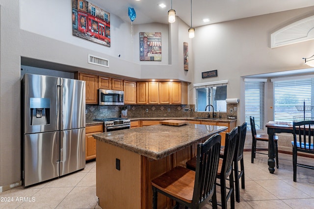 kitchen with sink, stainless steel appliances, high vaulted ceiling, backsplash, and light tile patterned floors