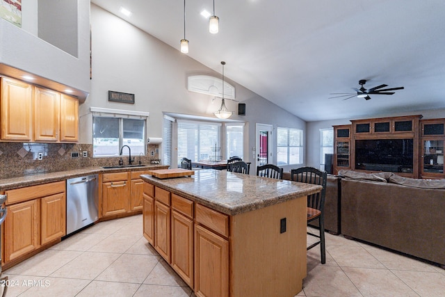 kitchen featuring dishwasher, a center island, a kitchen breakfast bar, decorative backsplash, and decorative light fixtures