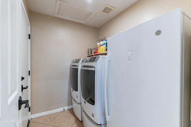 laundry area featuring washing machine and dryer and light tile patterned flooring