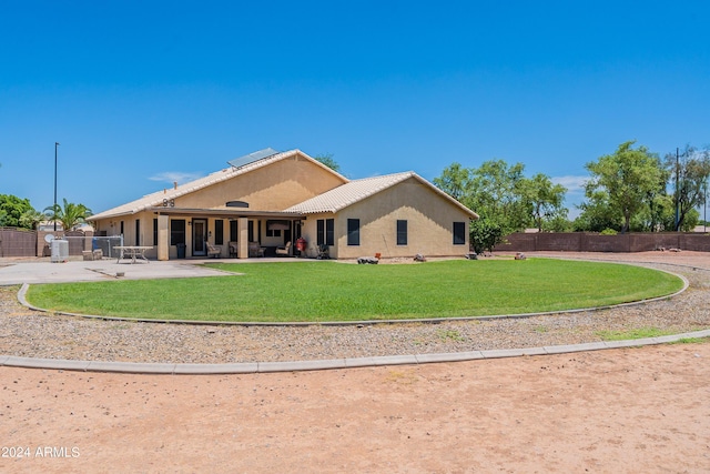 rear view of property with a yard and a patio