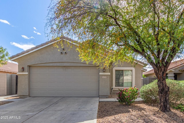 ranch-style house featuring stucco siding, a tiled roof, concrete driveway, and a garage