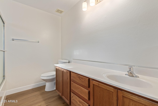 full bathroom with visible vents, toilet, wood finished floors, baseboards, and vanity