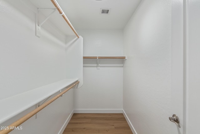 spacious closet featuring visible vents and wood finished floors