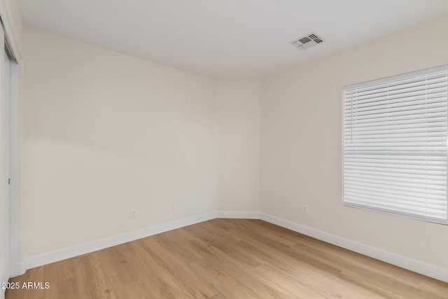 empty room with visible vents, baseboards, and light wood-style floors