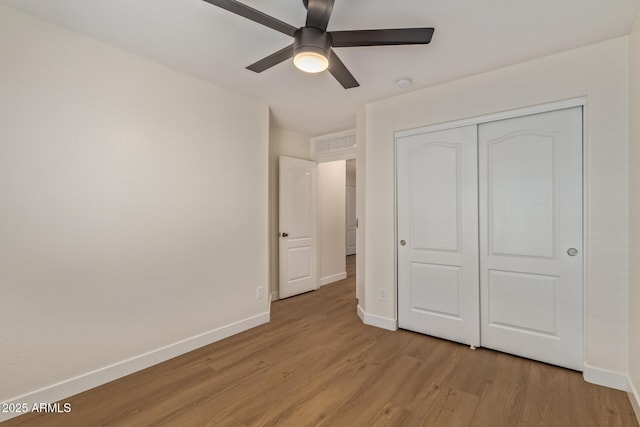 unfurnished bedroom with a ceiling fan, visible vents, baseboards, light wood-style floors, and a closet