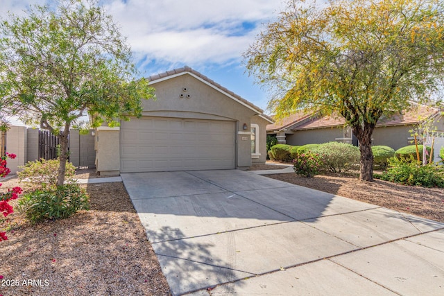 view of front of property with fence, a tiled roof, concrete driveway, stucco siding, and a garage