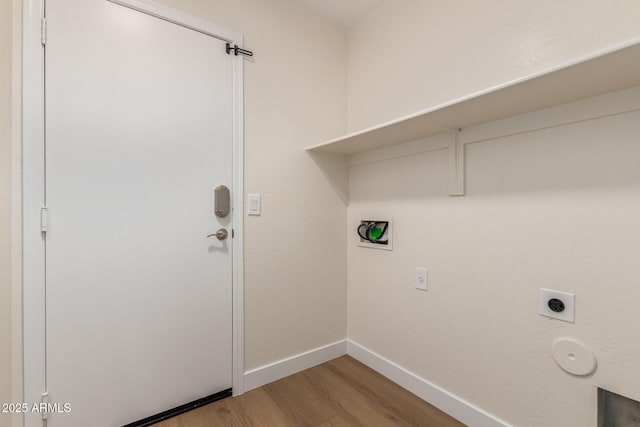 washroom with baseboards, hookup for an electric dryer, wood finished floors, and laundry area