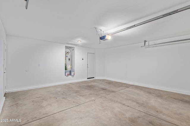 garage featuring electric water heater, a garage door opener, and baseboards