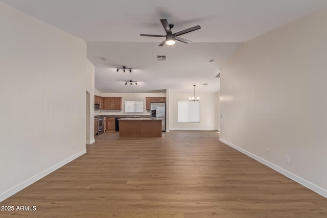 kitchen with light wood-style flooring, ceiling fan with notable chandelier, open floor plan, a center island, and stainless steel appliances