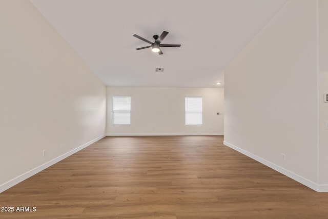 spare room featuring light wood-type flooring, baseboards, visible vents, and a ceiling fan